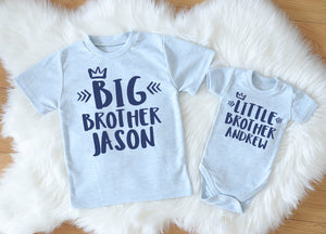 A charming light blue Big Brother t-shirt and matching Little Brother bodysuit, both personalized with the brothers' names, laid flat for a photo